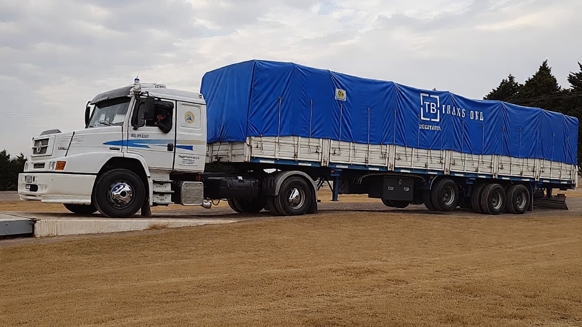 Equipo TRANSBEL: tractor con semirremolque de lona azul listo para salir